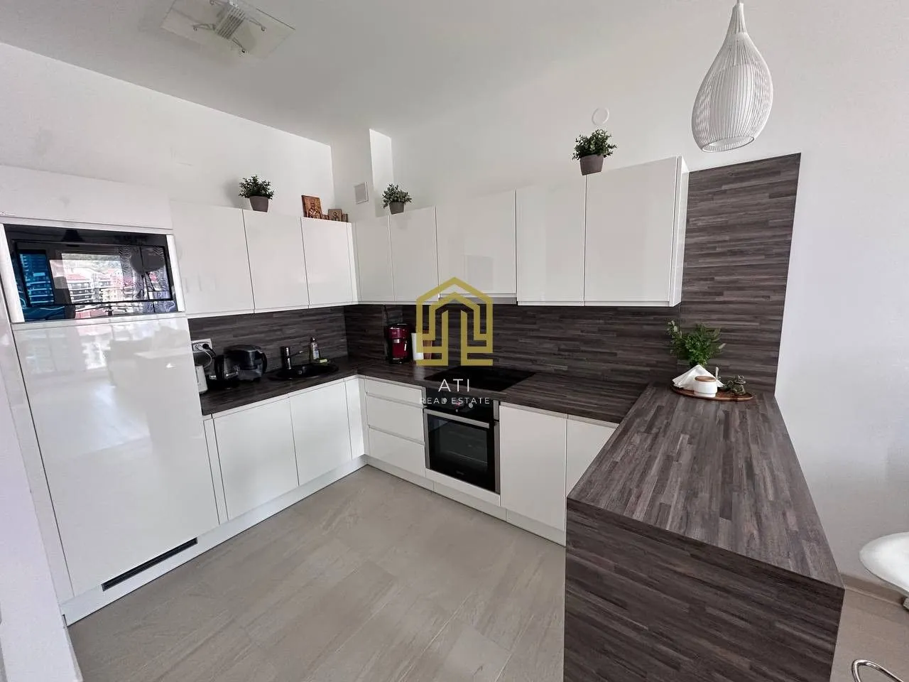 Modern kitchen with white cabinets and a wood-grain countertop.