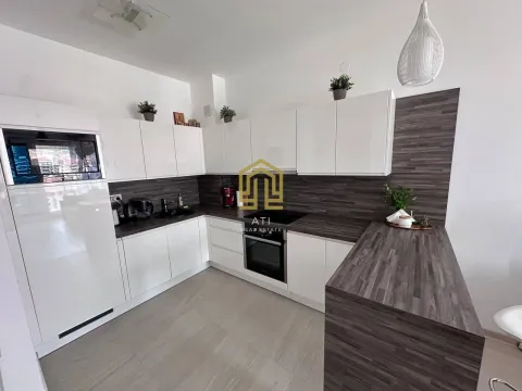 Modern kitchen with white cabinets and a wood-grain countertop. - image 6