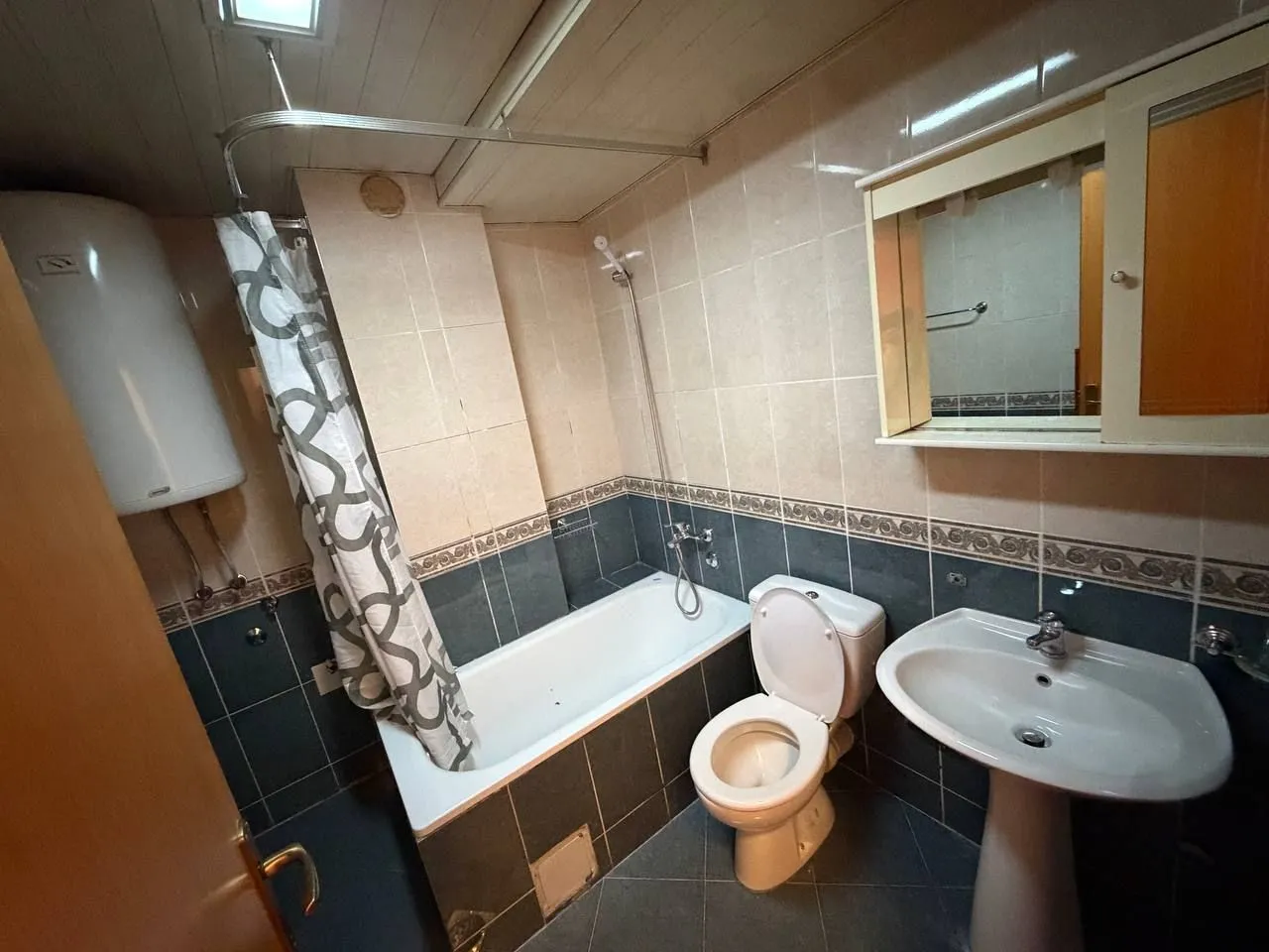 Compact bathroom with a bathtub, sink, and toilet.