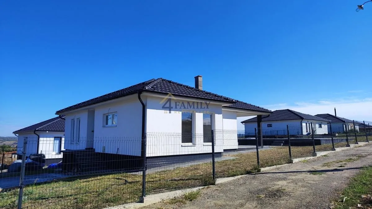 Exterior of a single-story house with a yard and fence.