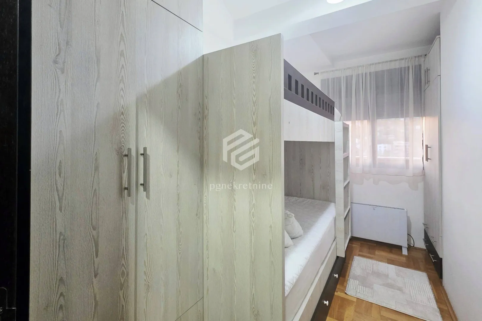 Small bedroom with a bunk bed and a fitted wardrobe.
