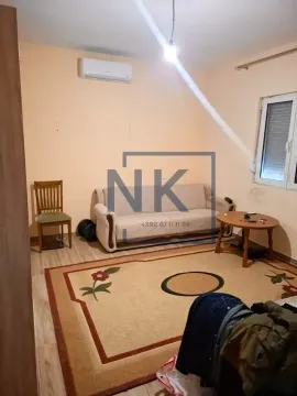 Living room with a sofa, rug, and air conditioning unit. - image 6