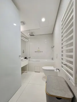 Modernly equipped bathroom with a bathtub and toilet in light tones. - image 10