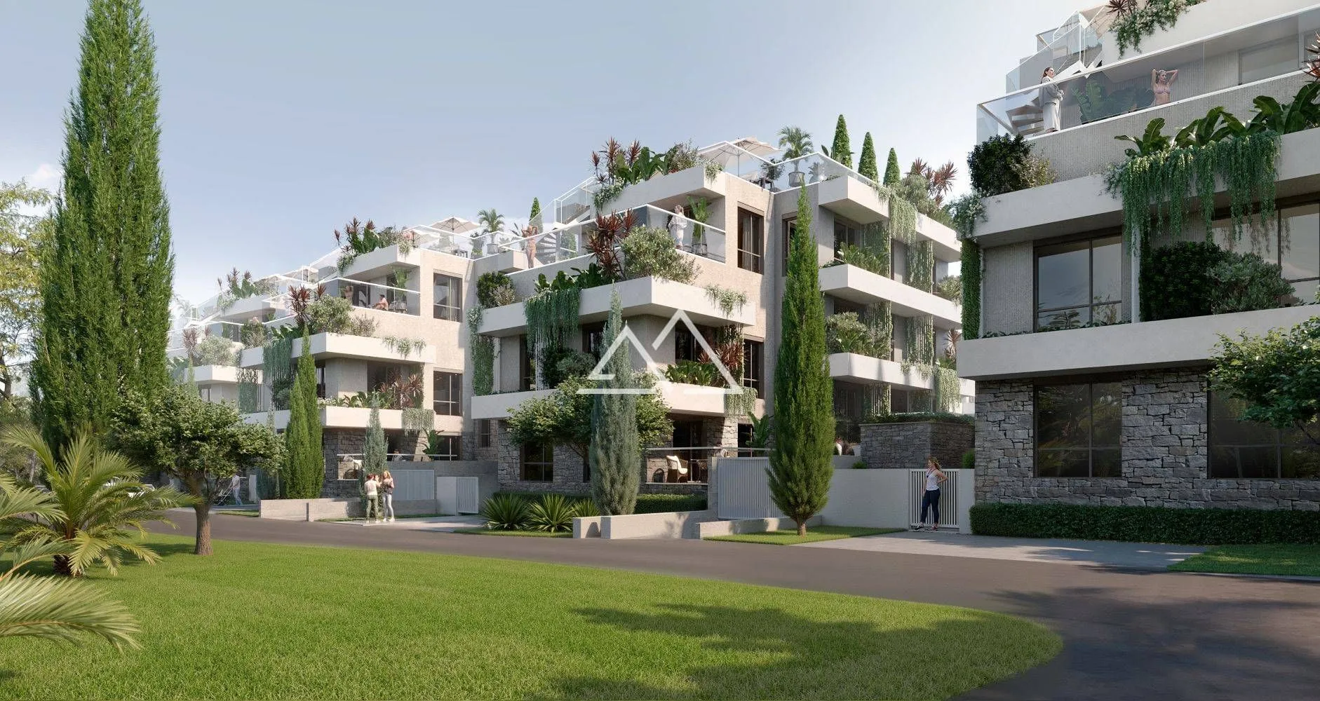 Pogled na spoljašnjost moderne stambene zgrade sa uređenim dvorištem i terasama.