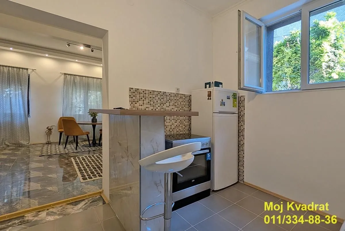 Small kitchen with a breakfast bar and an open passage to the dining area.
