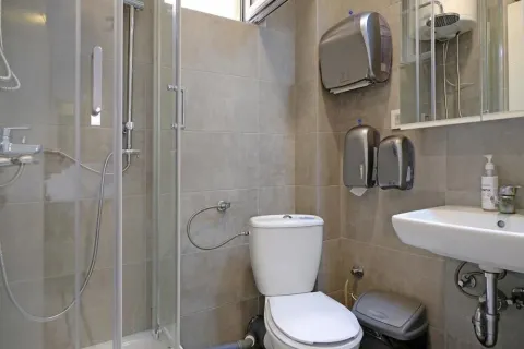 Kompaktno kupatilo sa tuš kabinom, toaletom i umivaonikom obloženo keramičkim pločicama. - image 14