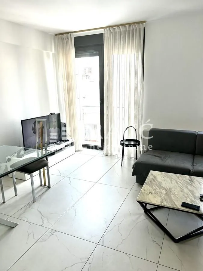 Living room with sofa, dining table and access to the terrace.