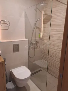 Modern bathroom equipped with a walk-in shower and a wall-mounted toilet. - image 10