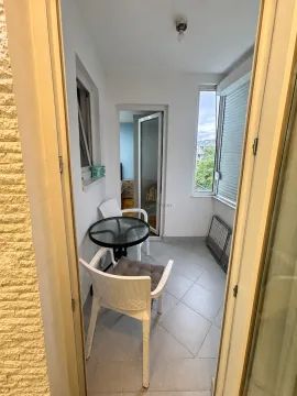 Zastakljeni balkon sa stočićem i dvije stolice. - image 10