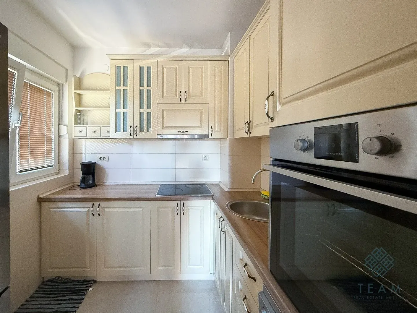 Kitchen with beige cabinets, wooden countertops, and a built-in oven.