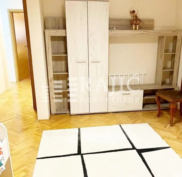 Living room with furniture and parquet flooring.