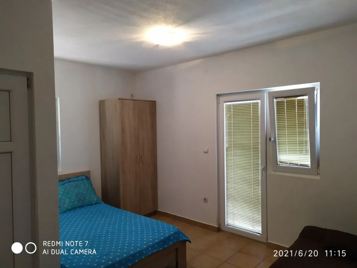 Furnished bedroom with a bed, wardrobe, and terrace access.