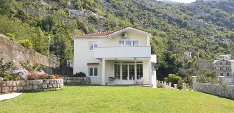 A two-story house with a landscaped lawn set against a mountain background. - image 2