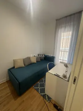 Small bedroom with a sofa bed and a desk. - image 17