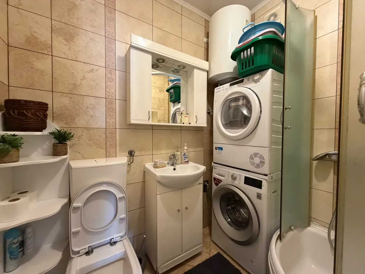 Small bathroom with sanitary ware, washbasin, shower cabin, and washing machine.