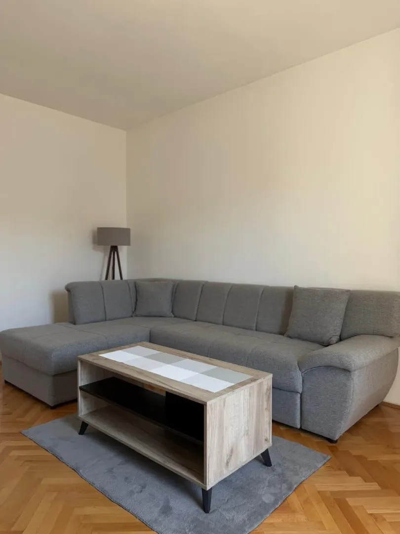 Living room with a sectional sofa, coffee table, and lamp.