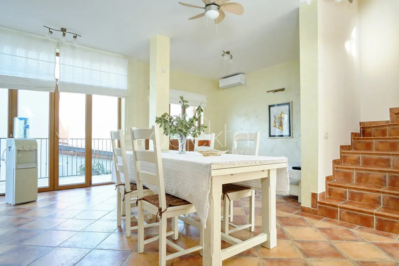 Spacious dining area with a wooden table, chairs, and stairs.