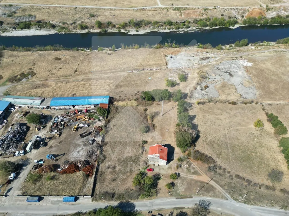 Pogled iz vazduha na zemljište i okolinu sa kućom i rijekom.