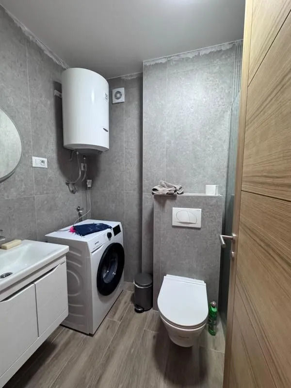 Bathroom equipped with a shower cabin, washbasin, toilet, water heater, and washing machine.