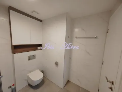 Modern bathroom with white tiles and a wall-mounted toilet. - image 5