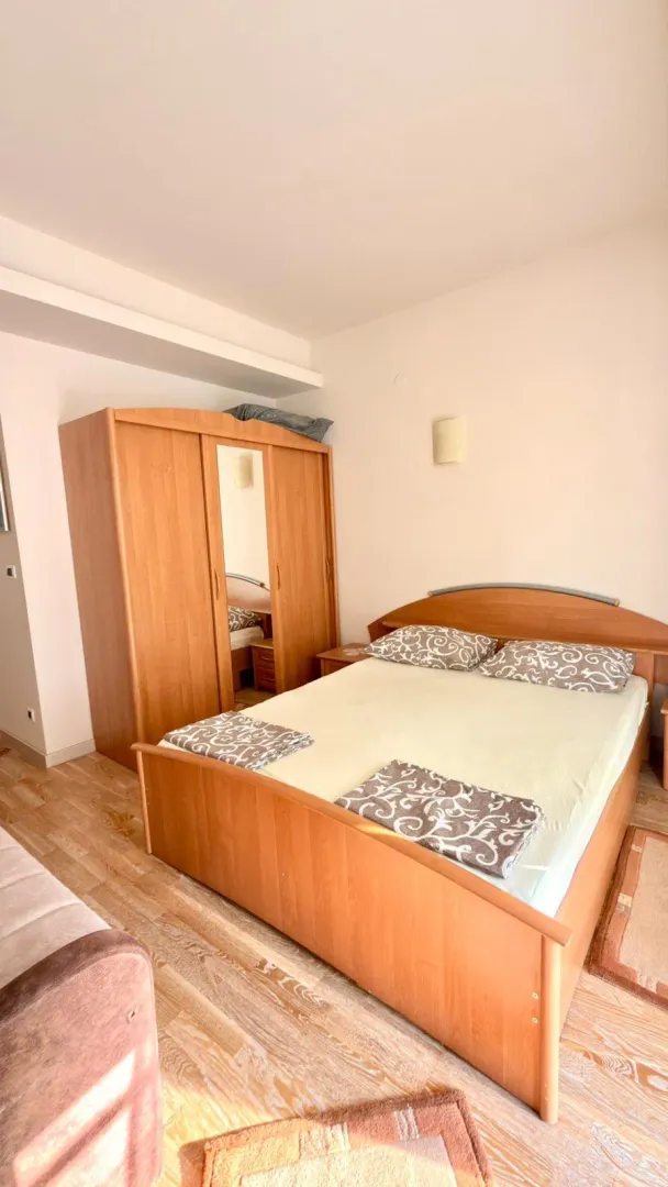 Bedroom with a double bed and a wooden wardrobe.