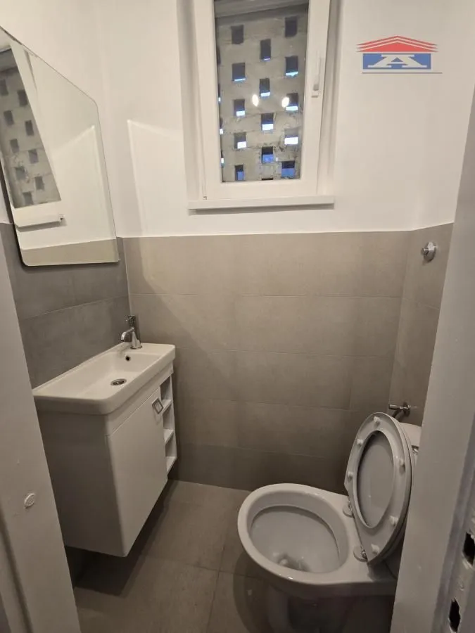 Manje kupatilo sa umivaonikom, ogledalom i toaletom.