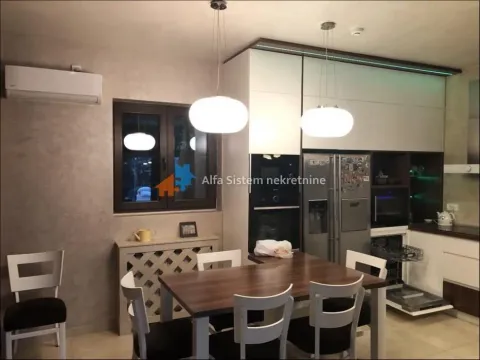 Modern kitchen with a dining table and built-in appliances. - image 3