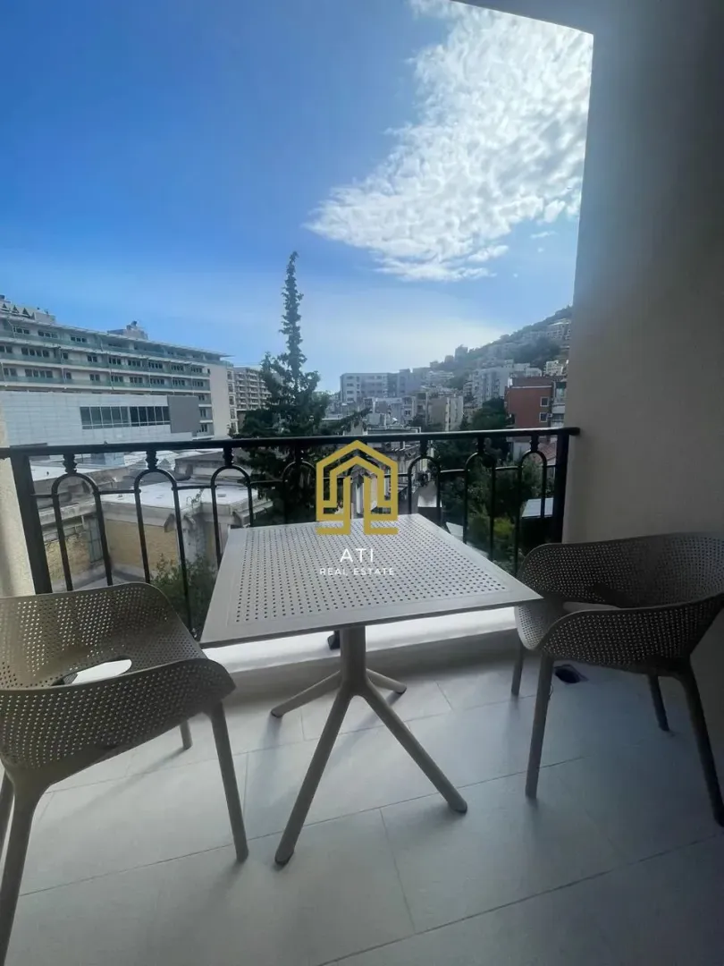 Furnished terrace with a table, chairs, and a city view.