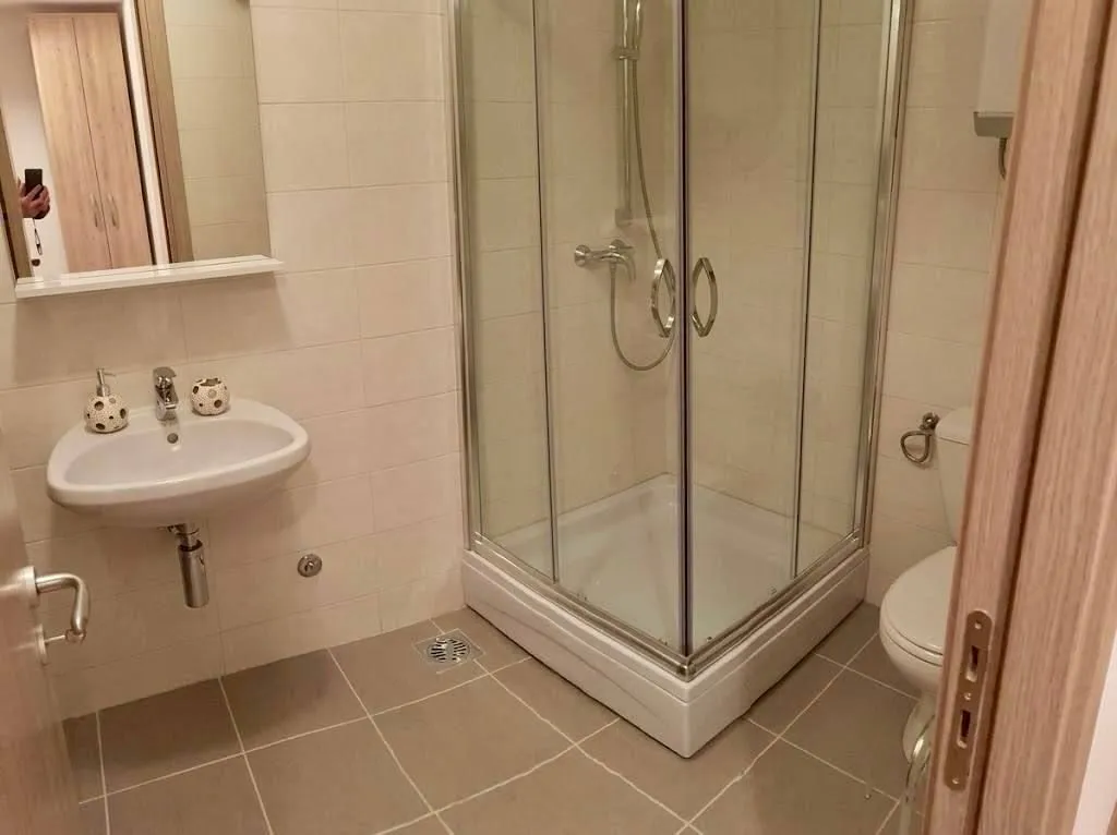 Savremeno opremljeno kupatilo sa tuš kabinom, umivaonikom i toaletom.