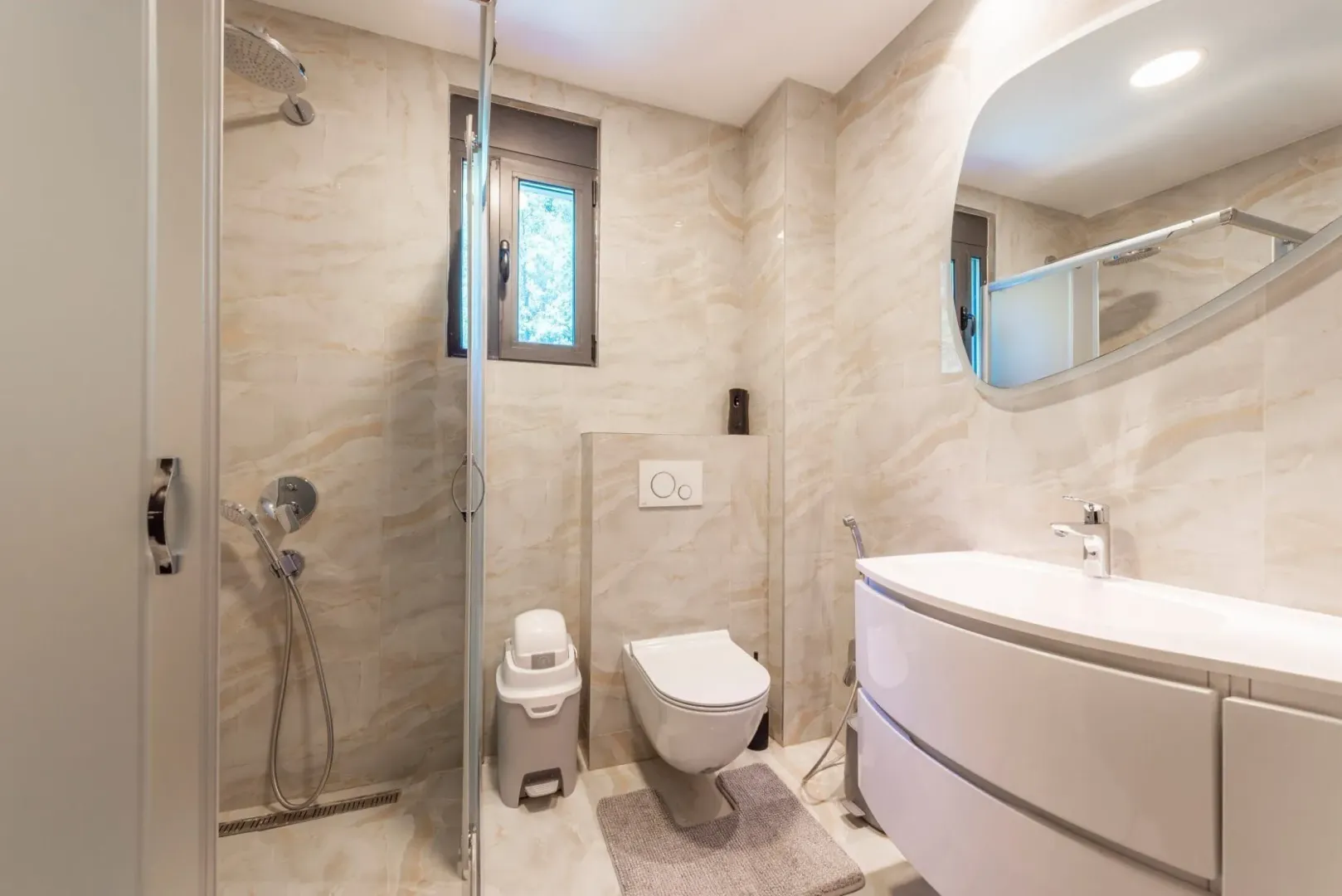 Bright and modern bathroom with a shower cabin and sink.