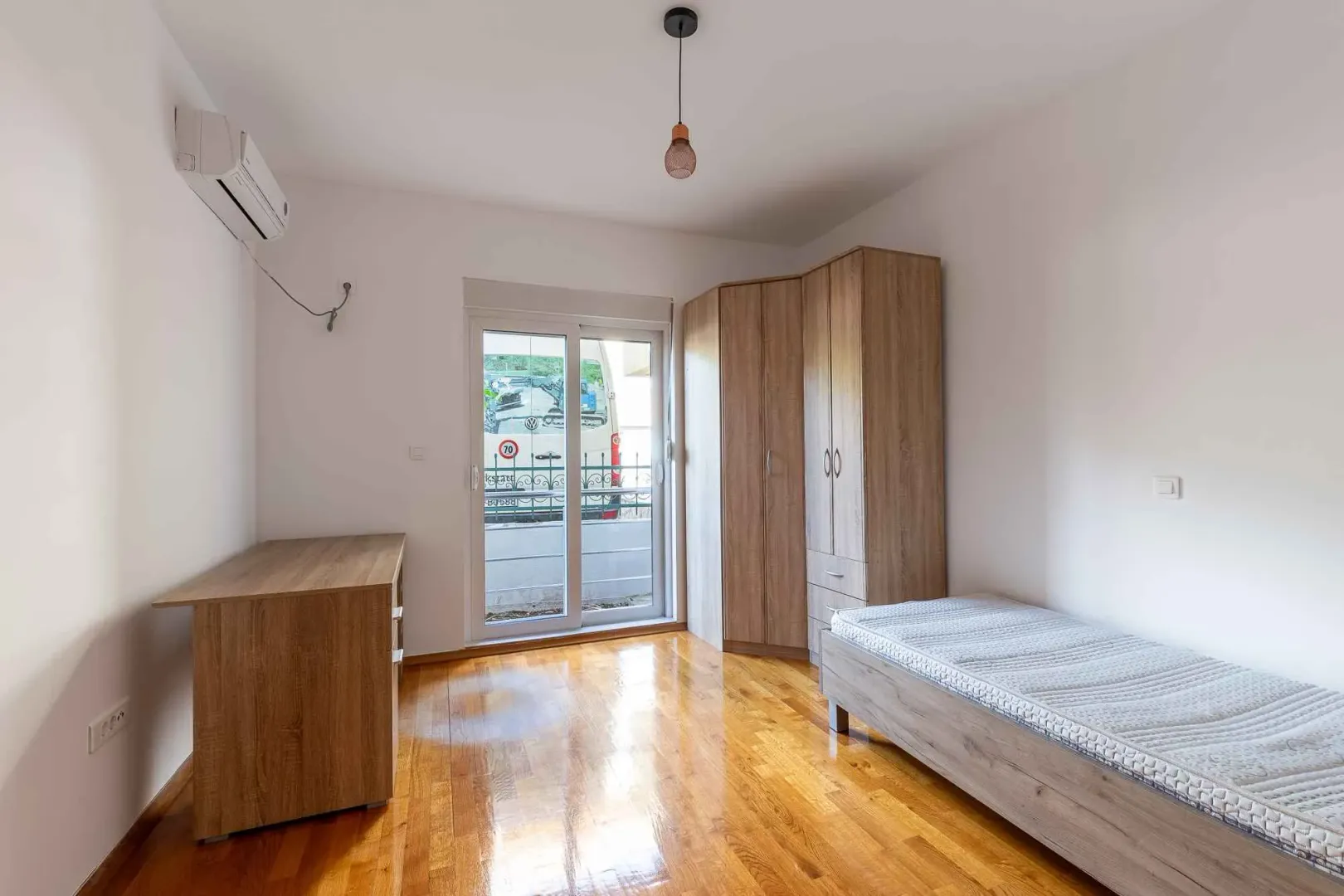 Small bedroom with a bed, wardrobe, and access to the terrace.
