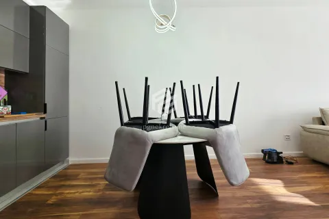 Dining table with chairs flipped upside down in the living room with a kitchen. - image 10