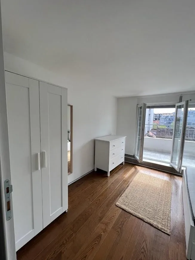 Bright bedroom with white furniture and access to the terrace.