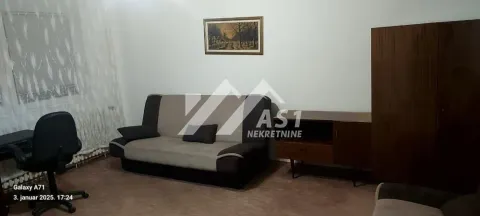 Dnevna soba sa kaučem, foteljom, radnim stolom i drvenim ormarima. - image 2