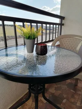 Balcony with a small table and chair. - image 22