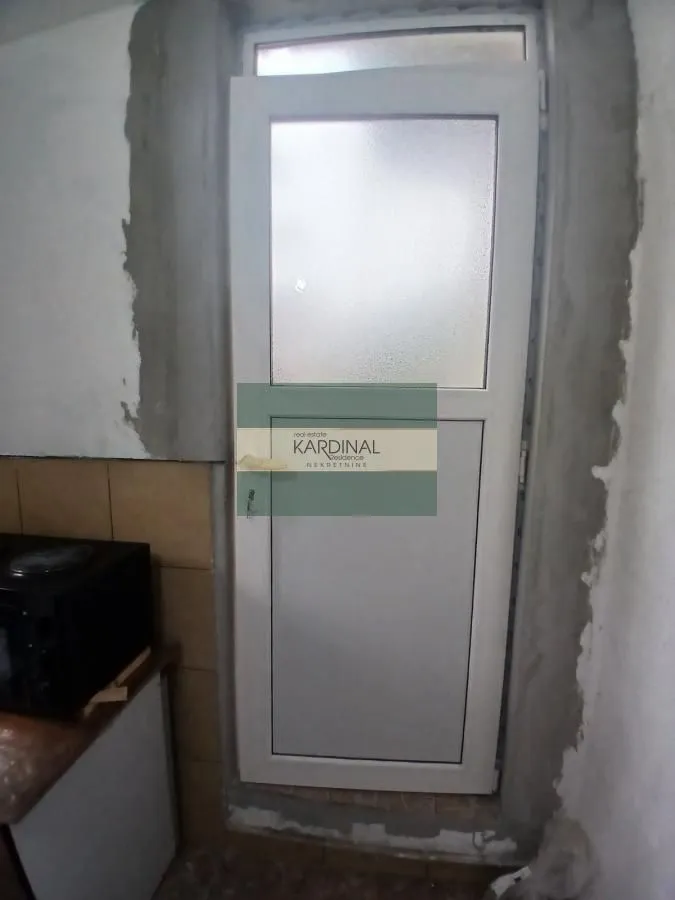 Bela PVC vrata sa mat staklom u zatvorenom prostoru.