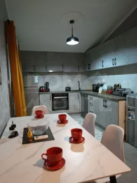 Modern kitchen with a dining table and grey kitchen cabinets. - image 11