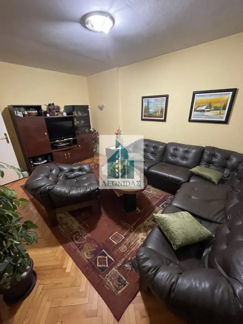 Living room with a sofa set, coffee table, and TV unit.