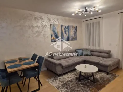 Living room with a sofa, dining table, and decorative wall. - image 4