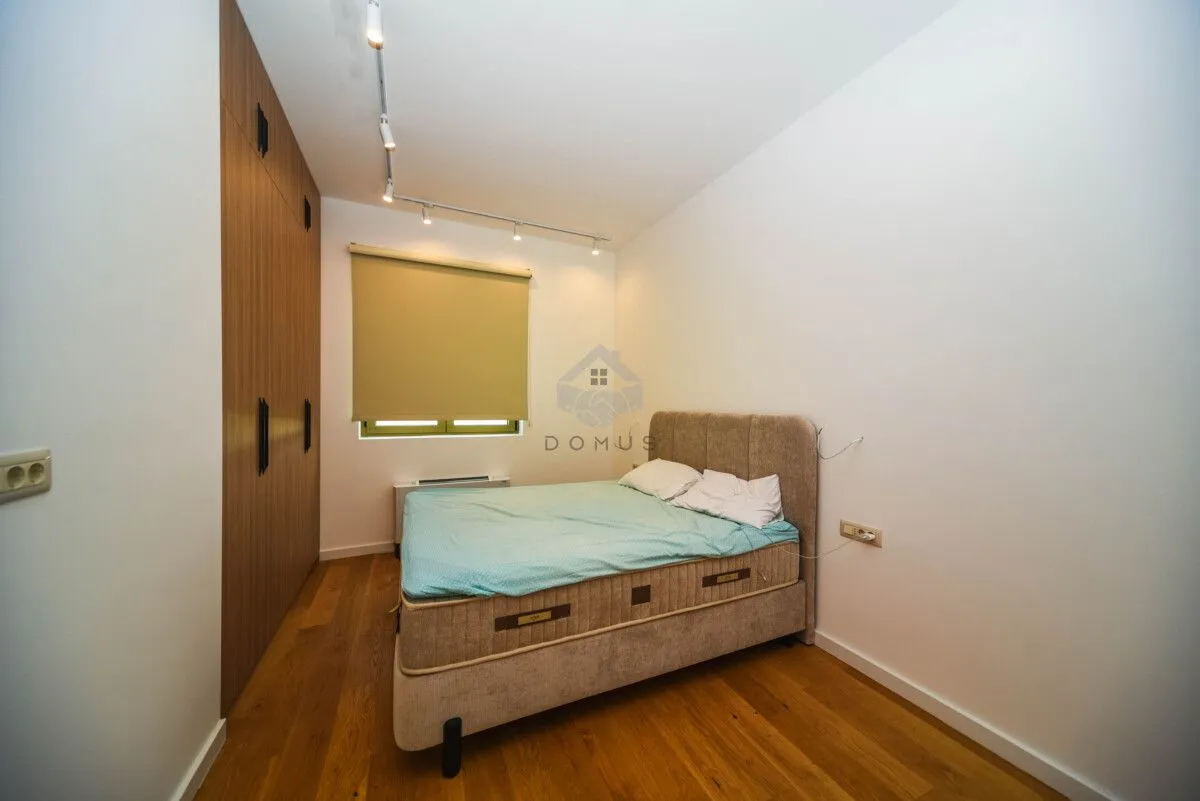 Bedroom with a double bed, wooden flooring, and a built-in wardrobe.