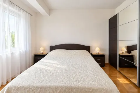 Tidy bedroom with a double bed, mirrored wardrobe, and nightstands. - image 7