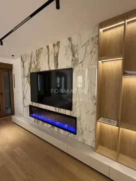Living room with a modern TV wall, built-in fireplace, and wooden shelving. - image 5