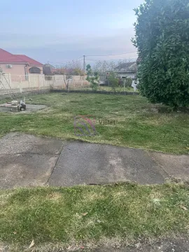 Prostrano travnato dvorište sa ogradom i okolnim kućama. - image 11