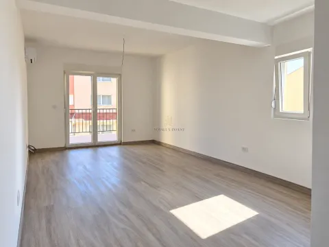 Prazna soba sa laminatom, bijelim zidovima i izlazom na balkon. - image 3