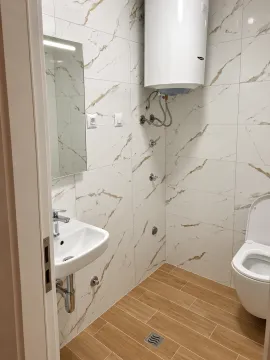 Manje kupatilo obloženo keramičkim pločicama sa tuš kabinom, umivaonikom, WC šoljom i bojlerom. - image 6