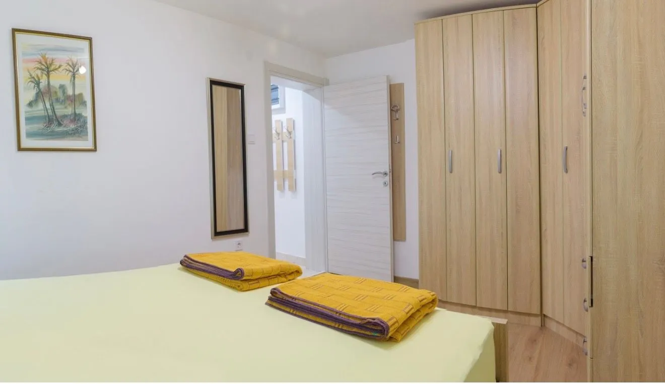 Furnished bedroom with a large wardrobe and a bed.