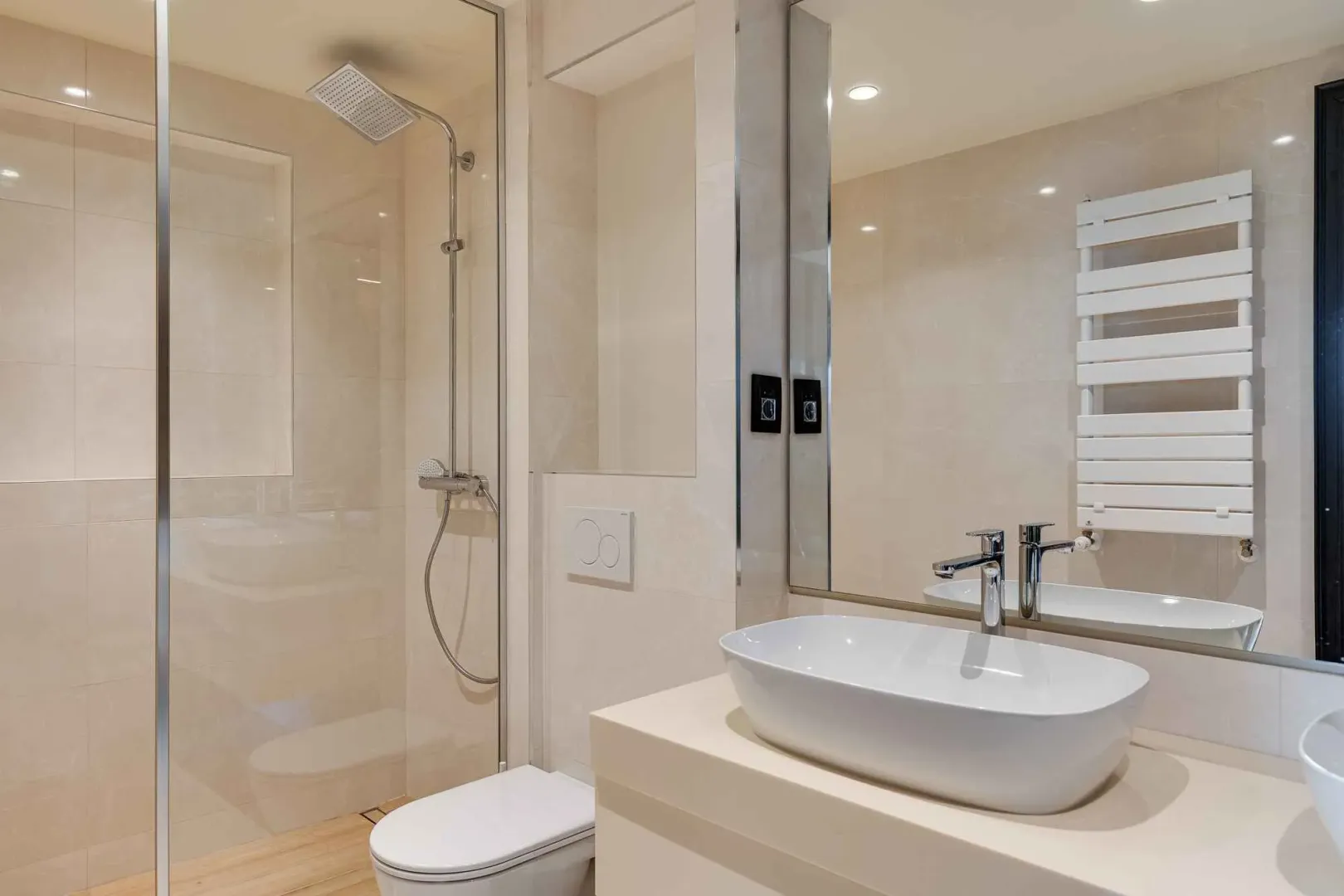 Moderno opremljeno kupatilo sa umivaonikom, tuš kabinom i wc šoljom.