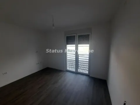 Prazna soba sa tamnim podom i staklenim balkonskim vratima. - image 5