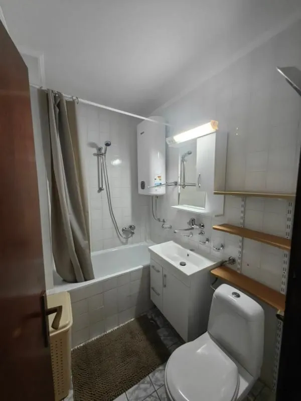 Manje kupatilo opremljeno tuš kabinom, umivaonikom i wc šoljom.