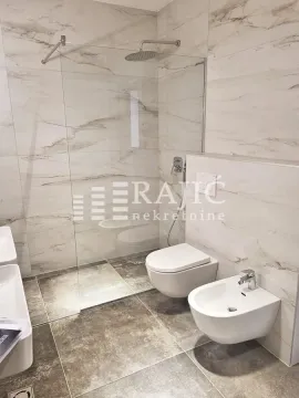 Modern bathroom with walk-in shower, sanitary ware, and marble tiles. - image 6